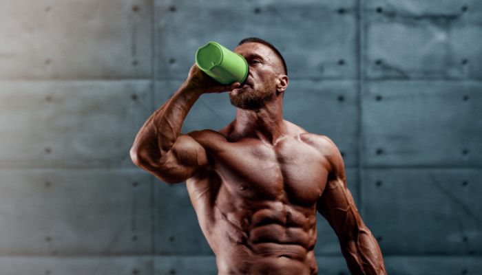 fit man drinking pre workout supplement